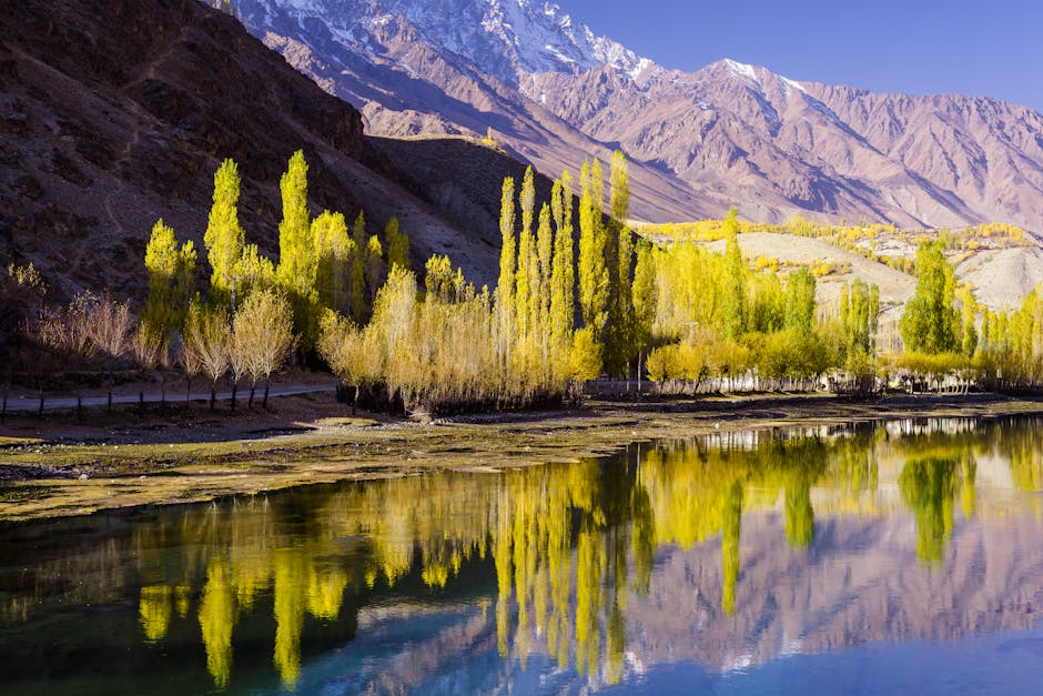 Stunning autumn scenery with vibrant trees reflected in Phander Lake, Pakistan.