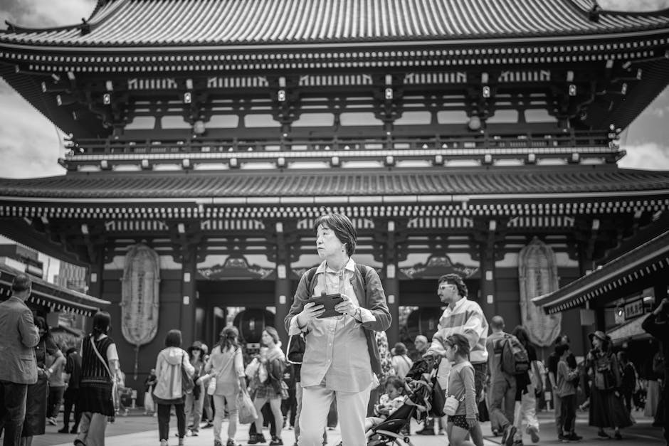 Black and white photo of people at Sensoji Temple in Tokyo, showcasing Japanese architecture.
