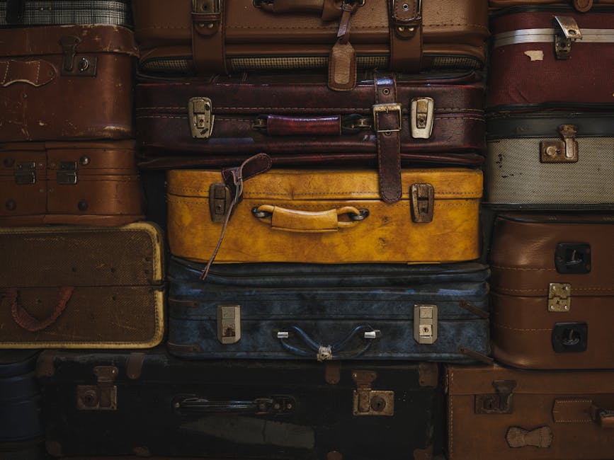 Vintage suitcases stacked in a rustic setting, showcasing classic travel charm.
