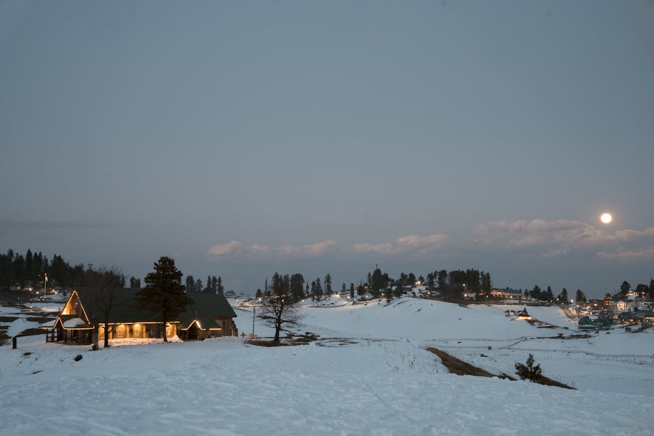 Serene winter night in Gulmarg, Kashmir with a scenic view of snow-covered hills and moonlight.