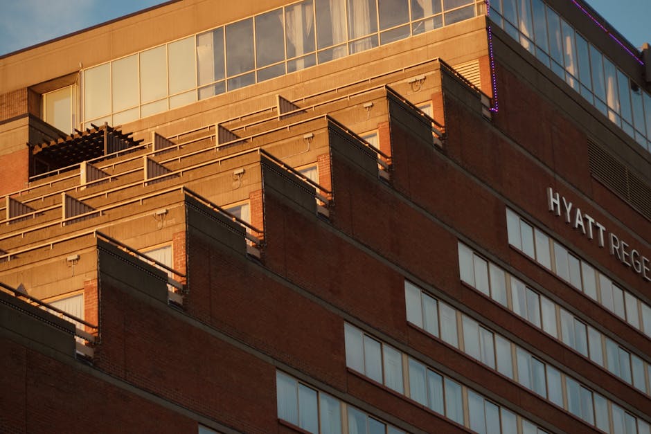 Dramatic view of Hyatt Regency hotel facade illuminated by sunset light.