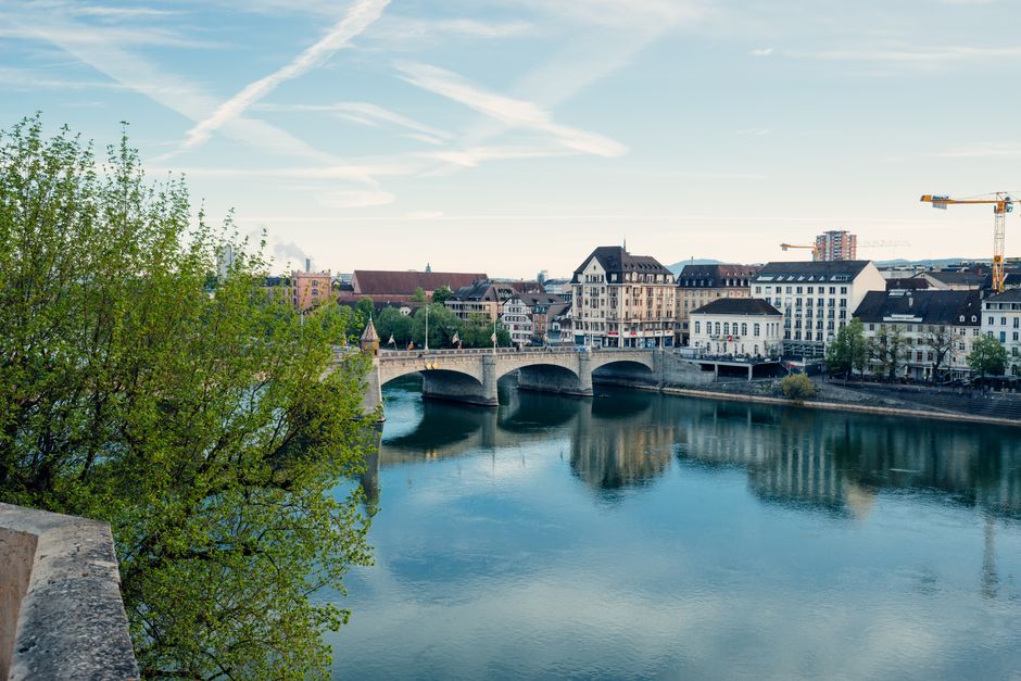 Beautiful view of Basel architecture and Rhine River reflecting sky and buildings.
