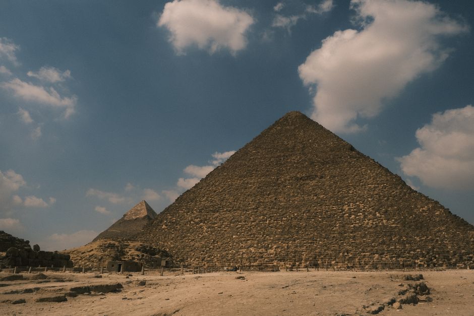 Captivating view of the Great Pyramid of Giza with a serene blue sky backdrop, showcasing ancient architecture.