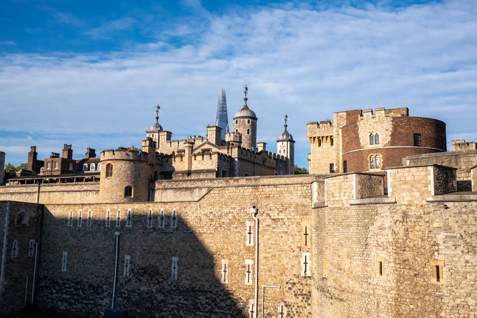Explore the historic Tower of London against a clear blue summer sky, showcasing its iconic architecture.