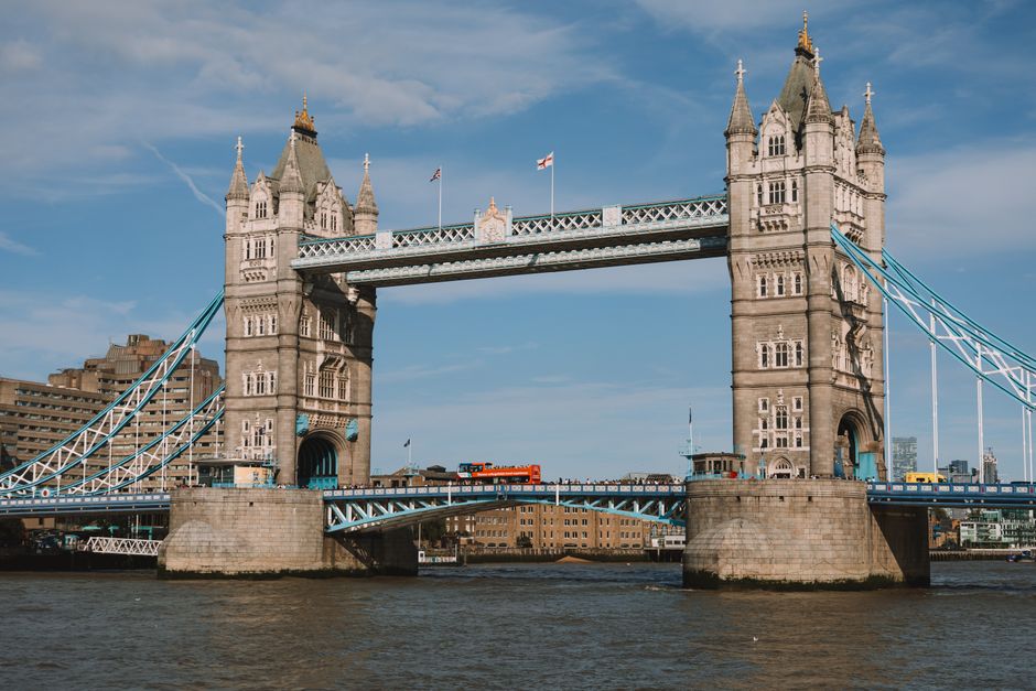 Stunning daytime shot of the iconic Tower Bridge in London, showcasing blue skies and an urban riverscape.